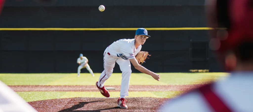 Baseball player pitching wearing custom Richardson uniform and hat
