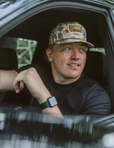 Person driving truck wtih custom Richardson hat and custom label logo