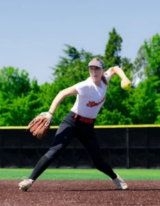 Softball player pitching wearing custom softball uniform and visor from Richardson