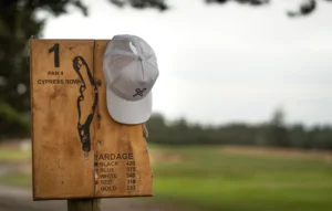Custom Richardson golf hat hanging on hole sign