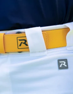 Close up of yellow Richardson softball belt and whtie softball pants