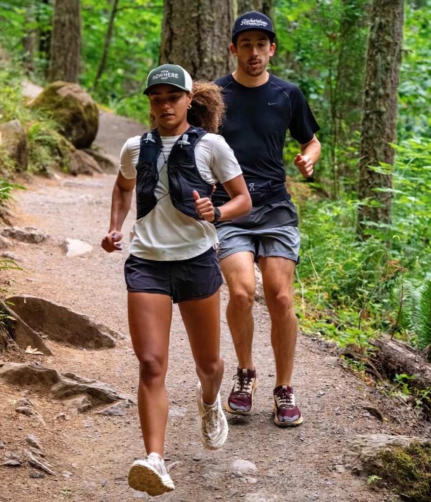 man and woman running down trail in custom richardson hats with logo decoration