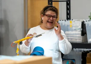 Employee smiling while working in a production area.